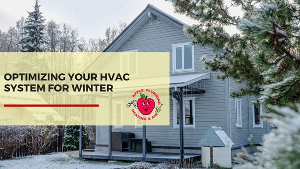 Front view of a grey home in winter with snow on the ground and trees, featuring a banner that reads optimizing your HVAC system for winter for Apple Plumbing Heating & Air.