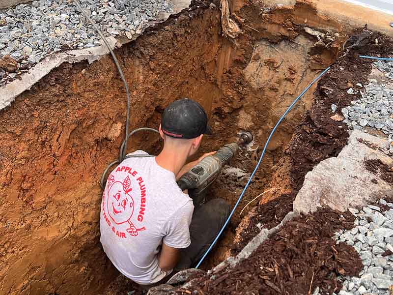 Apple Plumbing worker performing underground plumbing service.