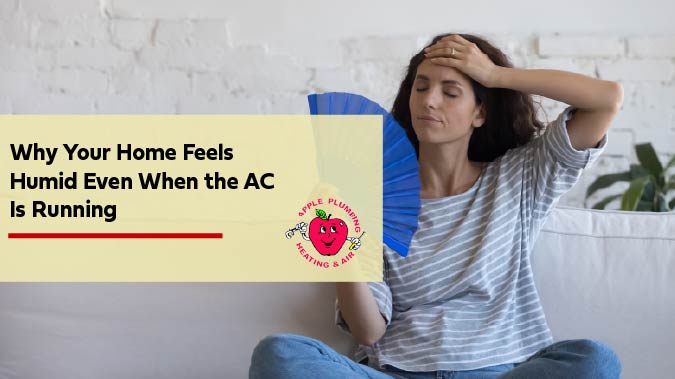 Woman using a paper fan to cool herself down while she sits on a couch.